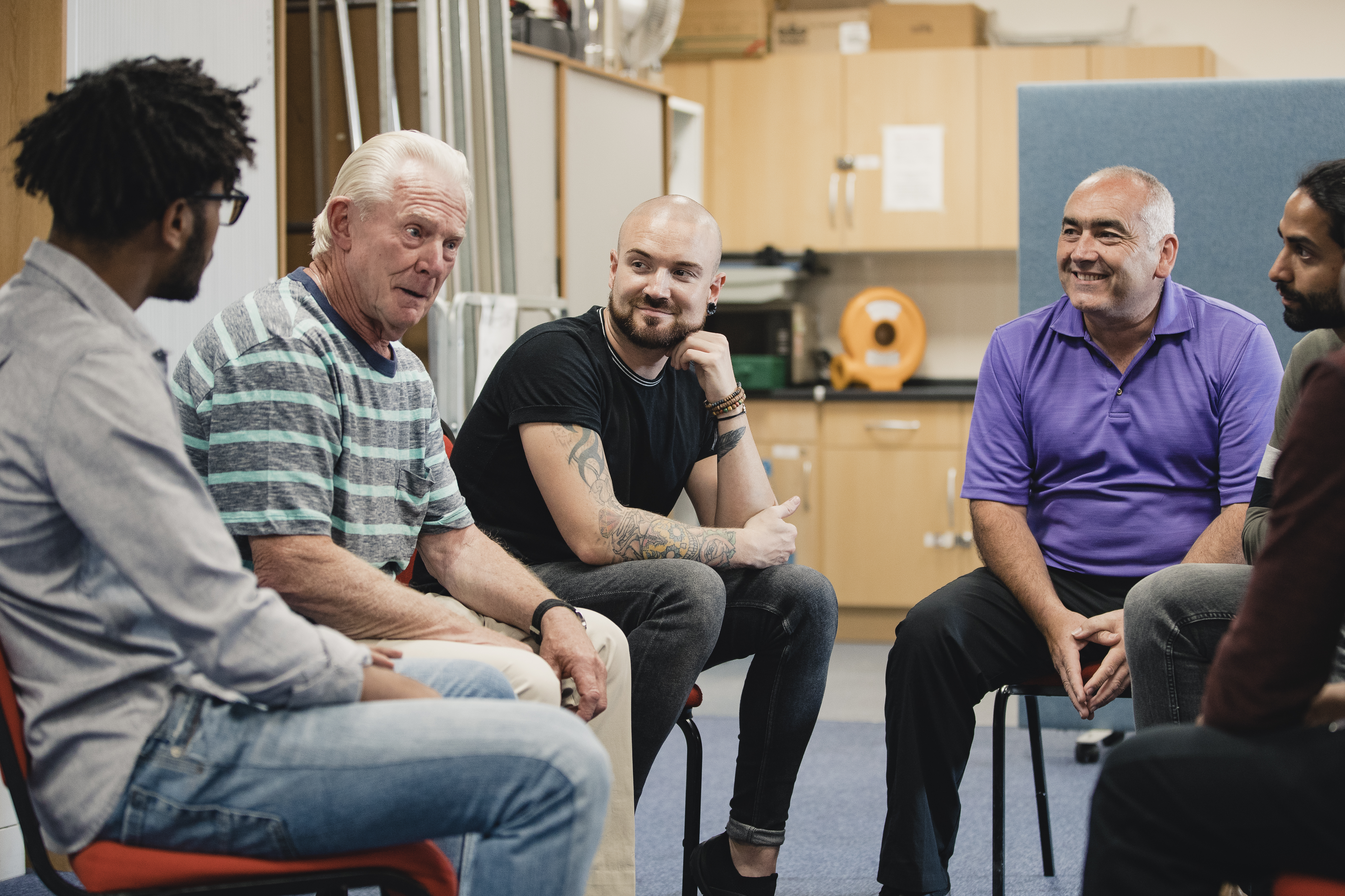 Men sat in a group talking